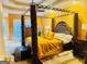 Luxurious bedroom with a four poster bed, tray ceilings, and gold accents at 1090 Crown River Pkwy, Mcdonough, GA 30252