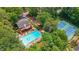 Aerial view showcasing a community pool and tennis courts, surrounded by mature trees and landscaping at 1952 Skidmore Cir, Lawrenceville, GA 30044