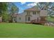 Expansive backyard featuring a wooden deck, lush green lawn, and mature trees, perfect for outdoor enjoyment and relaxation at 1952 Skidmore Cir, Lawrenceville, GA 30044
