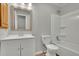 Bathroom boasts a shower-tub combo, updated vanity with a decorative mirror, and commode at 1952 Skidmore Cir, Lawrenceville, GA 30044