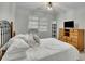 Well-lit bedroom with wooden dresser, a queen bed and large window for natural light at 1952 Skidmore Cir, Lawrenceville, GA 30044