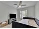This comfortable bedroom is furnished with a bed, television, ceiling fan and bright natural light at 1952 Skidmore Cir, Lawrenceville, GA 30044