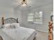 Bright bedroom with natural light, wooden dresser and queen bed with black headboard at 1952 Skidmore Cir, Lawrenceville, GA 30044