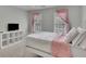 Cozy bedroom with a white metal bed frame, soft pink accents, and ample natural light at 1952 Skidmore Cir, Lawrenceville, GA 30044