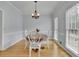 Cozy dining room with white chairs, hardwood floors, and lots of natural light at 1952 Skidmore Cir, Lawrenceville, GA 30044