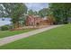 A view of the property showing a well maintained lawn and long driveway at 1952 Skidmore Cir, Lawrenceville, GA 30044