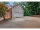 View of a two-car garage featuring a wide driveway and mature landscaping surrounding the property at 1952 Skidmore Cir, Lawrenceville, GA 30044