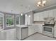 Open kitchen featuring white cabinets, tile floors, and stainless steel appliances at 1952 Skidmore Cir, Lawrenceville, GA 30044
