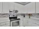 Well-lit kitchen with white cabinets, granite countertops, and stainless steel appliances at 1952 Skidmore Cir, Lawrenceville, GA 30044