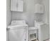 Bright laundry room features a white washer, dryer, and upper cabinets for storage at 1952 Skidmore Cir, Lawrenceville, GA 30044