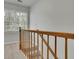 Carpeted staircase with wood railing ascends to the upper level, bathed in natural light at 1952 Skidmore Cir, Lawrenceville, GA 30044