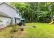 Expansive backyard featuring a fire pit, patio seating, and a lush lawn surrounded by trees at 2093 Kolb Ridge Sw Ct, Marietta, GA 30008