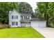 Charming two-story home with white siding, black shutters, a cozy front porch, and an attached two-car garage at 2093 Kolb Ridge Sw Ct, Marietta, GA 30008