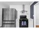 Modern kitchen with stainless steel fridge and stove, white cabinets, and a view into the adjacent room at 2093 Kolb Ridge Sw Ct, Marietta, GA 30008
