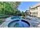 Backyard featuring a lovely pool, hot tub, patio, and lush landscaping at 2996 Walkin Horse Trl, Buford, GA 30519