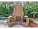 Outdoor fireplace in a backyard patio with pool at 2996 Walkin Horse Trl, Buford, GA 30519