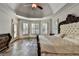 Bright main bedroom with herringbone wood floors and a decorative tray ceiling at 2996 Walkin Horse Trl, Buford, GA 30519