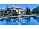 Backyard pool and patio are surrounded by lush trees, offering a relaxing outdoor space at 2996 Walkin Horse Trl, Buford, GA 30519