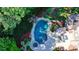 Aerial view of the in-ground pool with spa and waterfall, surrounded by lush landscaping at 2996 Walkin Horse Trl, Buford, GA 30519