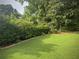 Lush, green backyard featuring a well-manicured lawn, mature trees, and a landscaped border with rock edging at 388 Talcott Nw Cir, Marietta, GA 30064