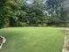 Lush green backyard with a large, well-maintained lawn, mature trees, and landscaped border creating a private oasis at 388 Talcott Nw Cir, Marietta, GA 30064