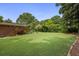 Spacious backyard featuring a manicured lawn, mature trees, and a wooden deck at 388 Talcott Nw Cir, Marietta, GA 30064
