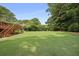 Expansive backyard featuring a large, well-manicured lawn, wooden deck, and mature trees at 388 Talcott Nw Cir, Marietta, GA 30064