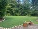 Expansive green backyard with manicured lawn, mature trees, and a decorative rock border providing a serene outdoor space at 388 Talcott Nw Cir, Marietta, GA 30064