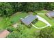 Angle view of a one story home surrounded by mature trees and lawn with a curved driveway at 388 Talcott Nw Cir, Marietta, GA 30064