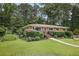 Charming one-story brick home with manicured front lawn, mature landscaping, and welcoming walkway at 388 Talcott Nw Cir, Marietta, GA 30064