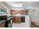 Traditional kitchen featuring wooden cabinets, stone countertops, black appliances, and floral wallpaper at 388 Talcott Nw Cir, Marietta, GA 30064