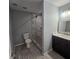 This bathroom features a glass shower with stone tiles, modern fixtures, and gray wood grain flooring at 487 Eastside Dr, Dacula, GA 30019