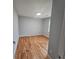 This empty bedroom is freshly painted with hardwood floors and a window letting in light at 487 Eastside Dr, Dacula, GA 30019