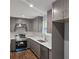 This kitchen features gray cabinets, modern appliances, and quartz countertops for a sleek design at 487 Eastside Dr, Dacula, GA 30019