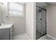 Bathroom featuring a shower with sliding glass doors and marble tile, and a window with blinds at 1985 Thomasville Se Dr, Atlanta, GA 30315