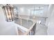 Upstairs hallway with a view of foyer chandelier, wood and black iron railing at 4541 Meadow Club Dr, Suwanee, GA 30024