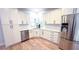 Bright kitchen with white cabinets, stainless steel appliances, and hardwood floors at 4541 Meadow Club Dr, Suwanee, GA 30024
