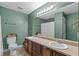 Bright bathroom featuring a double sink vanity with lots of lighting and a toilet at 9507 Greens Mill Ct, Loganville, GA 30052