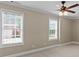 Bright bedroom with two windows, ceiling fan, and neutral carpeting at 9507 Greens Mill Ct, Loganville, GA 30052