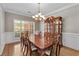 Bright dining room featuring a large window, chandelier, and traditional wood furnishings at 9507 Greens Mill Ct, Loganville, GA 30052