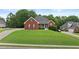 Brick home with a lush green lawn and an ample driveway offers great curb appeal at 9507 Greens Mill Ct, Loganville, GA 30052