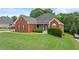Beautiful brick home with a green lawn and inviting front porch, perfect for relaxing at 9507 Greens Mill Ct, Loganville, GA 30052