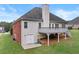 View of home's rear elevation, deck, siding, brick accents, and walkout basement at 9507 Greens Mill Ct, Loganville, GA 30052