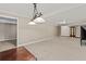 Expansive living room featuring neutral carpet, decorative lighting fixture and doorways to other rooms at 9507 Greens Mill Ct, Loganville, GA 30052
