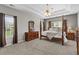 Spacious main bedroom showcasing trey ceilings, neutral tones, and large windows at 9507 Greens Mill Ct, Loganville, GA 30052