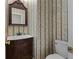 Charming powder room with a vanity, marble countertop, and vintage-style wallpaper at 9507 Greens Mill Ct, Loganville, GA 30052