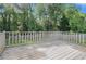 Spacious wooden deck overlooking the backyard with wooden perimeter railing and views of mature trees at 1663 Pounds Sw Rd, Stone Mountain, GA 30087