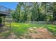 Large backyard with green grass, mature trees, a wooden fence and a ground level deck at 1663 Pounds Sw Rd, Stone Mountain, GA 30087