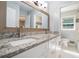 Bright bathroom features double vanity with granite countertops, framed mirror and tile flooring at 1663 Pounds Sw Rd, Stone Mountain, GA 30087
