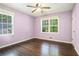 Bedroom with hardwood floors, ceiling fan, and natural light from two windows at 1663 Pounds Sw Rd, Stone Mountain, GA 30087